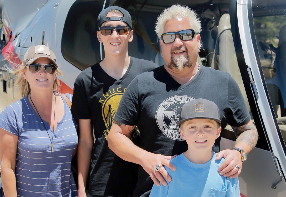The Fieri family stands in front of a helicopter