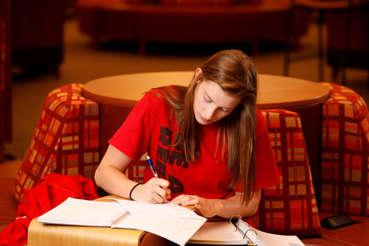 A student taking notes on her notebook.