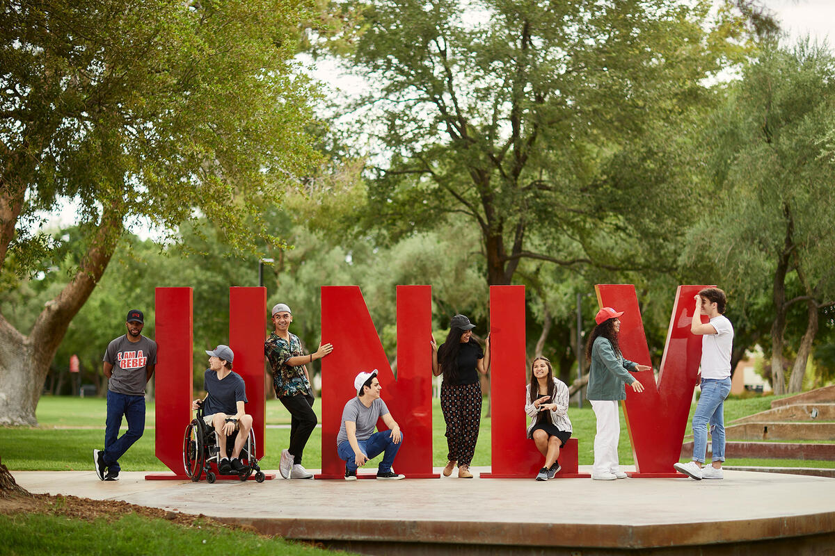 A group of people posing around a U-N-L-V sign