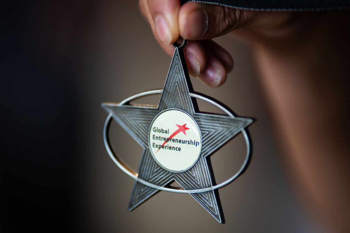 Person holding star medallion that says &quot;Global Scholarship Entrepreneurship&quot;