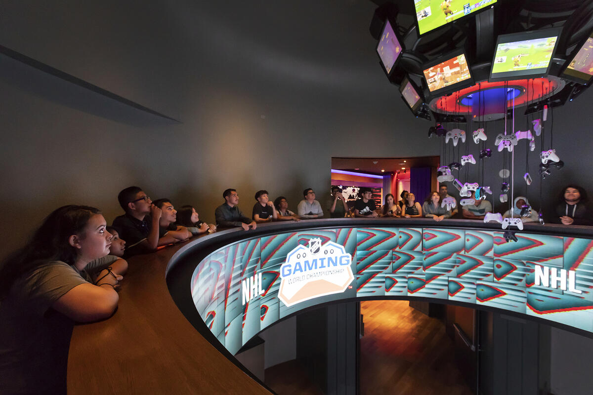 People sitting in a circular table room with &quot;Gaming World Championship&quot; on it