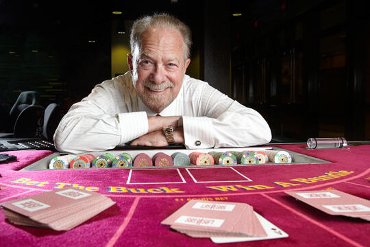 Dr. Mark Yoseloff poses behind gaming table