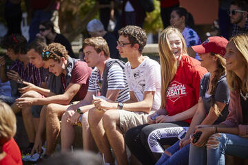 Students sitting outside during a daytime Presidential Debate event.