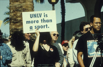 protester holding sign “UNLV is More Than a Sport,”