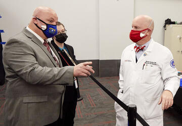 Man talking to a doctor, both wearing masks