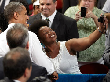 Woman taking a selfie with President Obama.