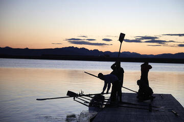 silhouettes of rowing team at sunrise