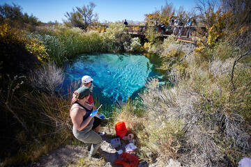 researchers taking samples around a spring