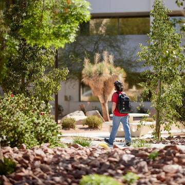 student walking past xeriscape garden