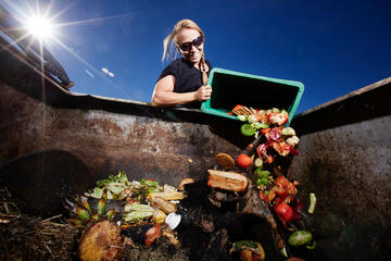 woman adding food waste to composter