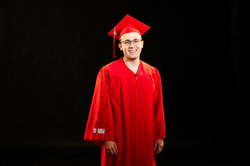 Benjamin Khavkin in a red cap and gown ready to celebrate graduation