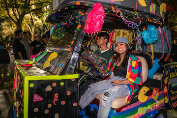 Students participate in a brightly-decorated float on a golf cart
