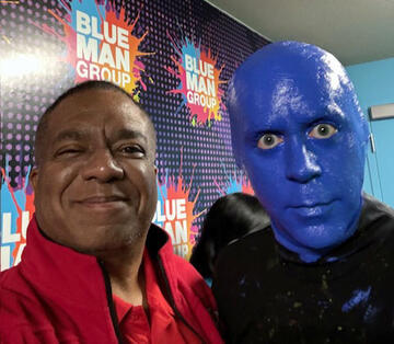 man posing with Blue Man Group performer
