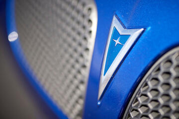 close up of section of blue car's grill and logo