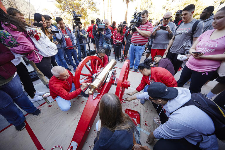 A crowd gathers to paint the Fremont Cannon scarlet.
