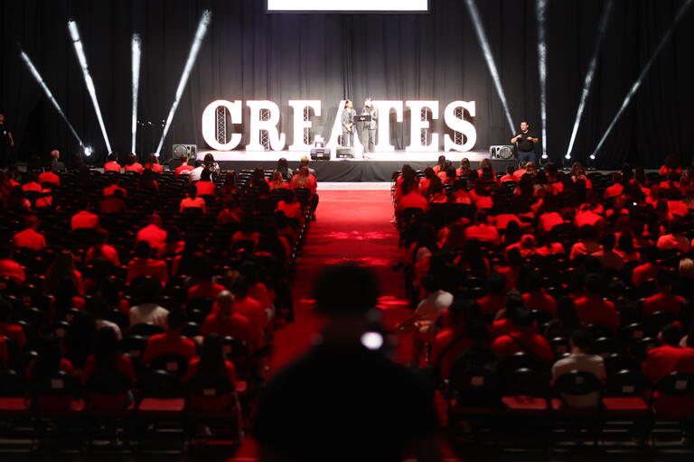 Audience and stage with letters &quot;CREATES&quot; lit up