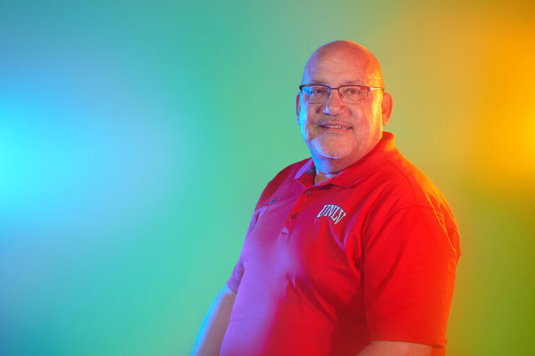 man in red polo shirt with colored background
