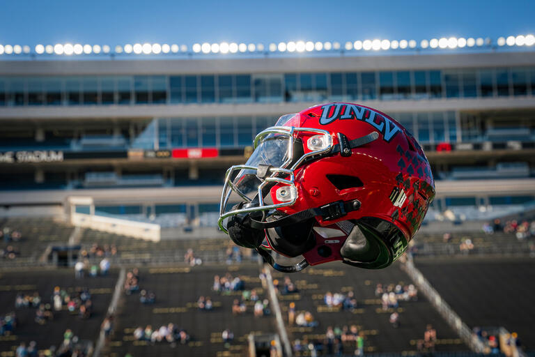 UNLV football helmet in the air at a football game.