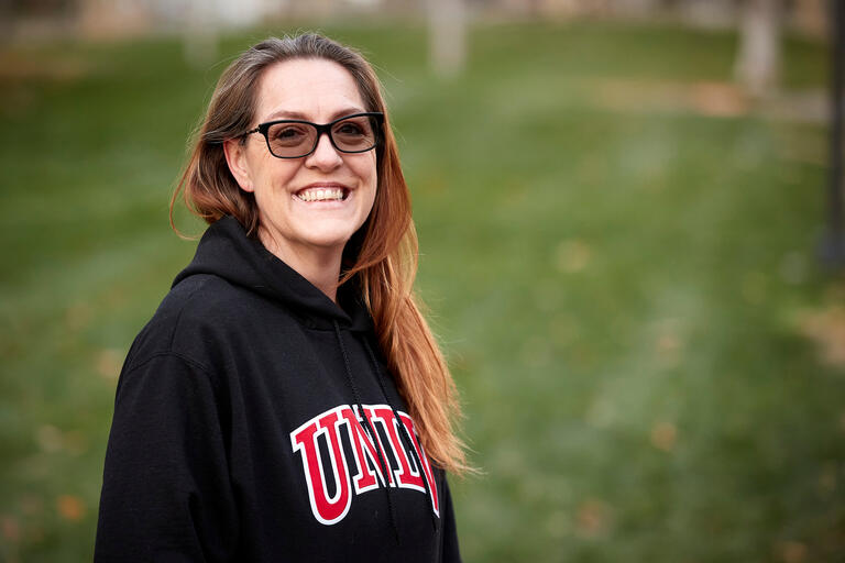 woman wearing black UNLV hoodie and glasses