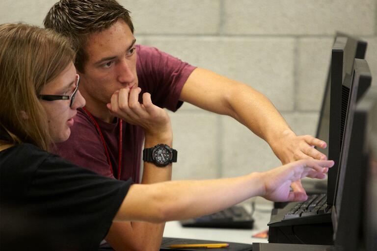 Tutor works with a student using a computer