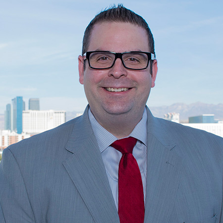 A man with glasses smiling.