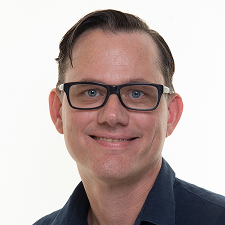 A man with glasses smiling