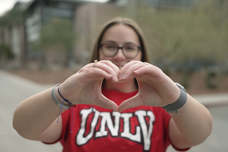 Person holding hands together in a heart sign