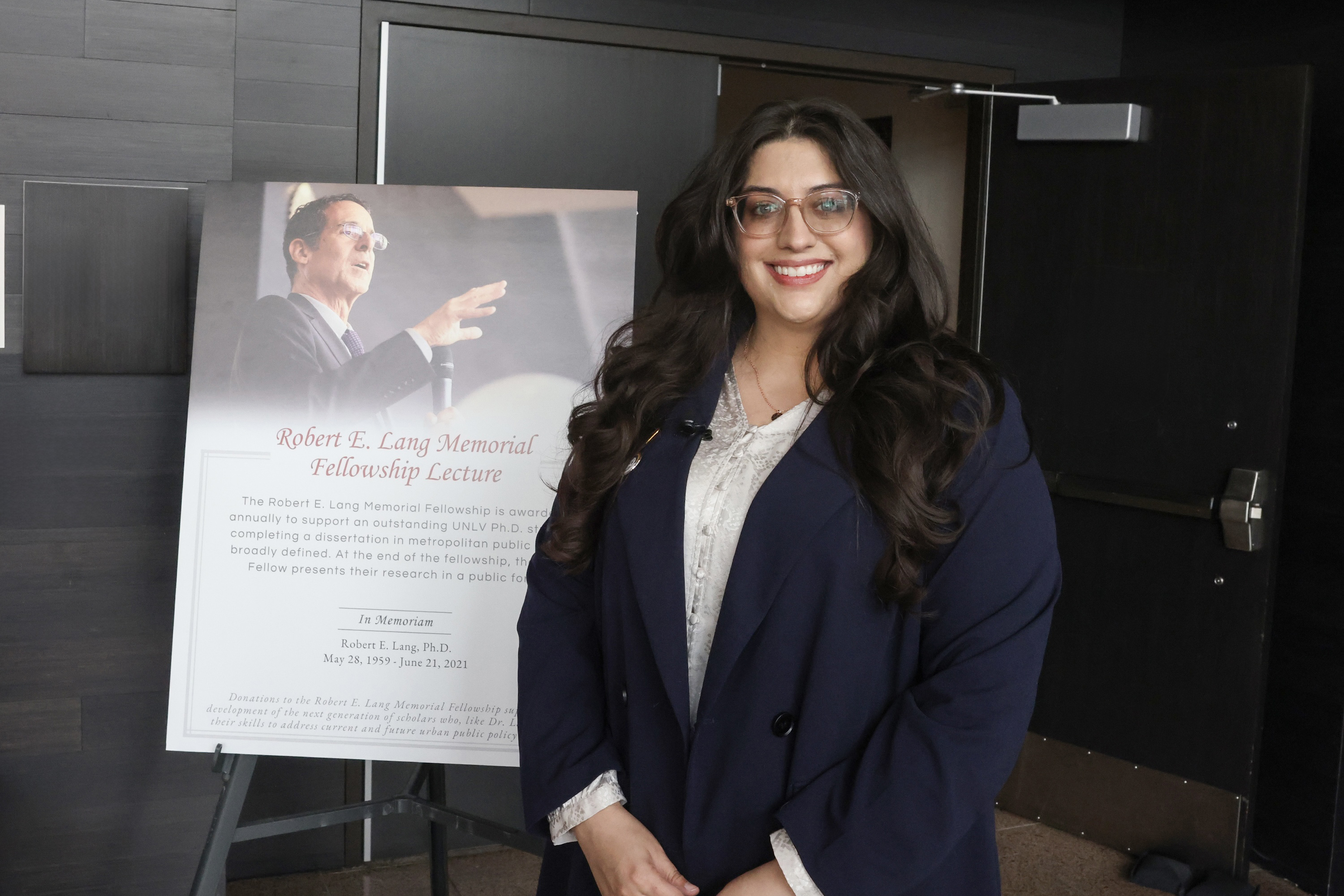 A person smiling with a presentation board showing