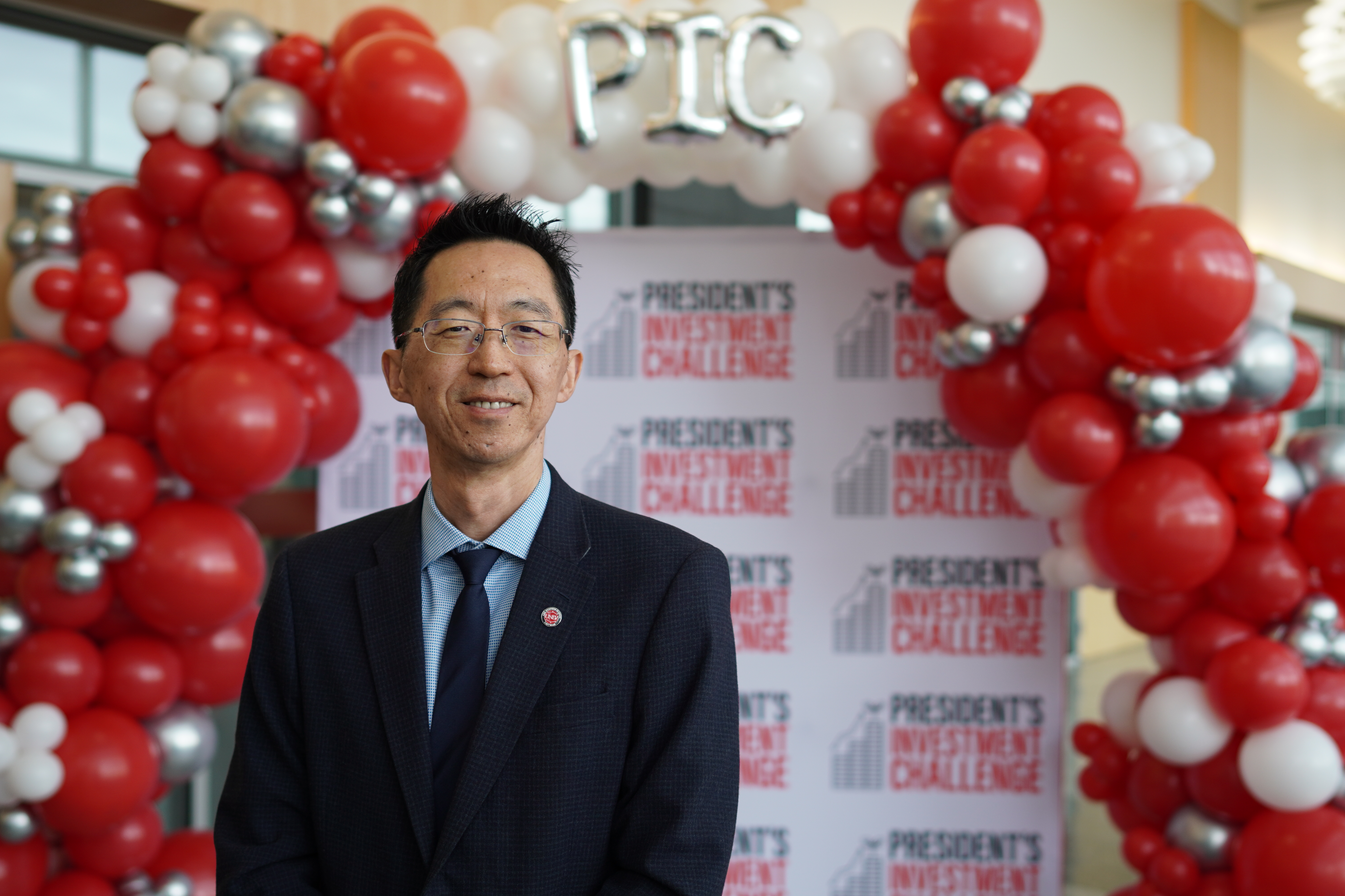 A man standing by a backdrop