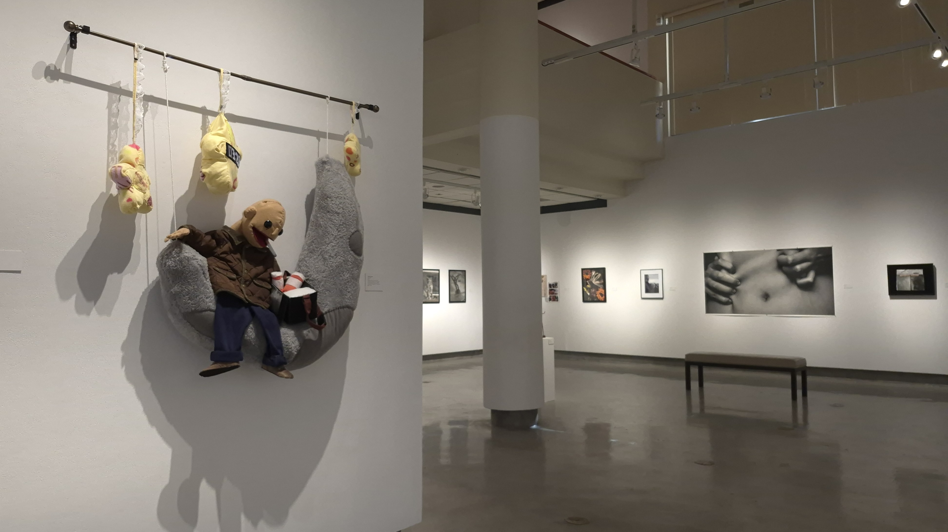 A wall with a curtain rod attached with a puppet sitting on a plush moon and plush stars