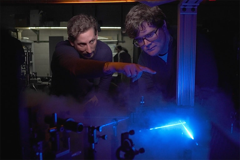 Students working with a laser in a lab.
