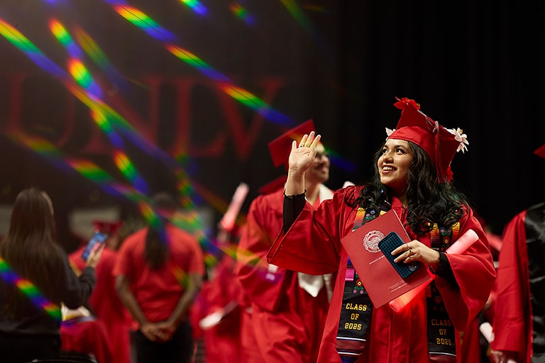 Student waves during commencement