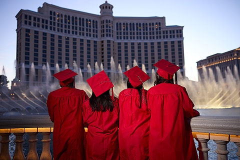 Students in their caps and gowns watch the Bellagio fountains
