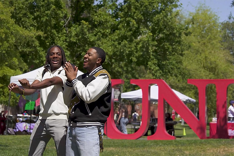 Two students clapping and dancing