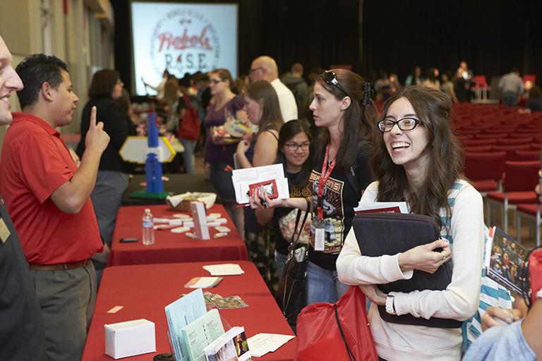 Students gathering around a table during a convention