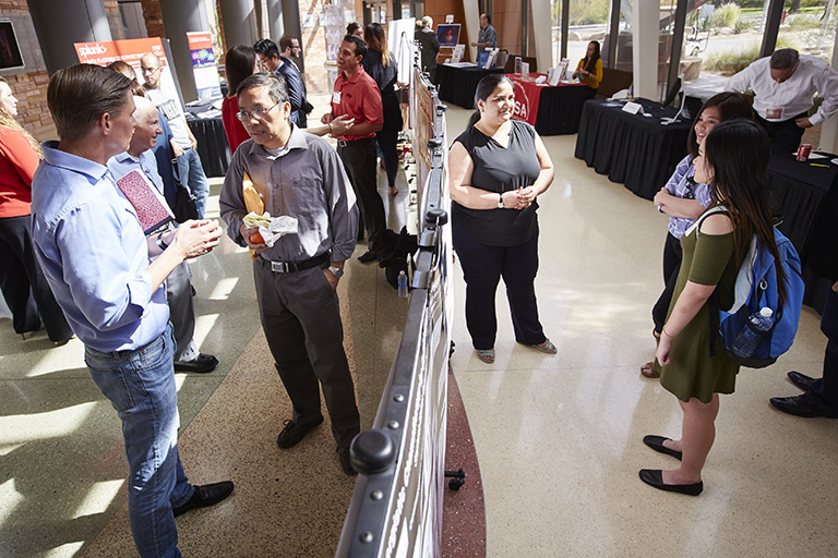 Group of people standing and discussing topics with each other.