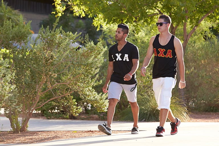 Two fraternity members walking