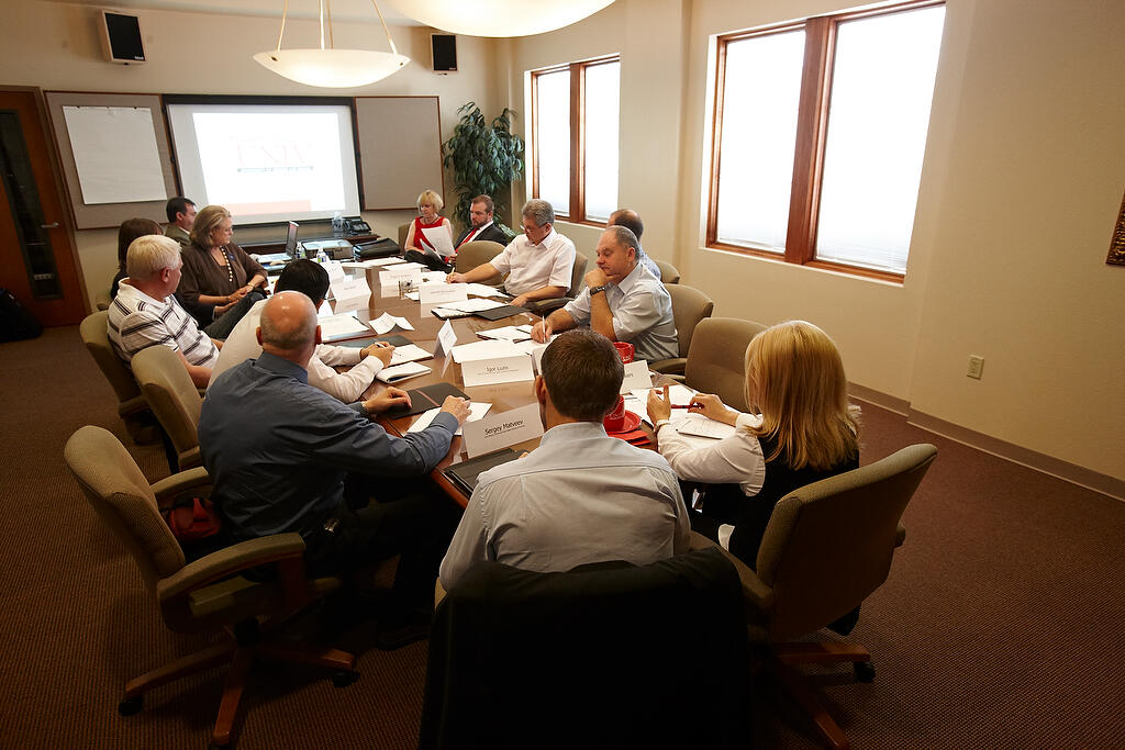 A group of people sit down for a meeting