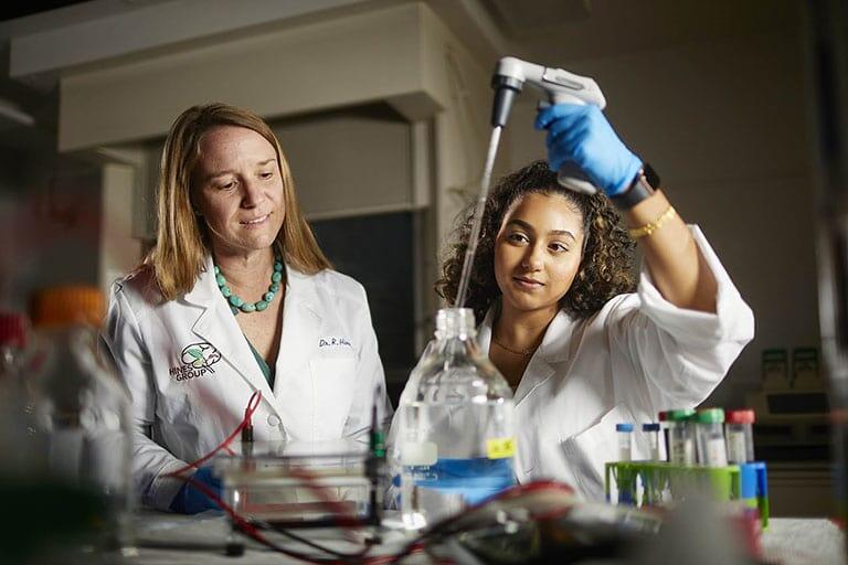 Students in lab coats doing research work.