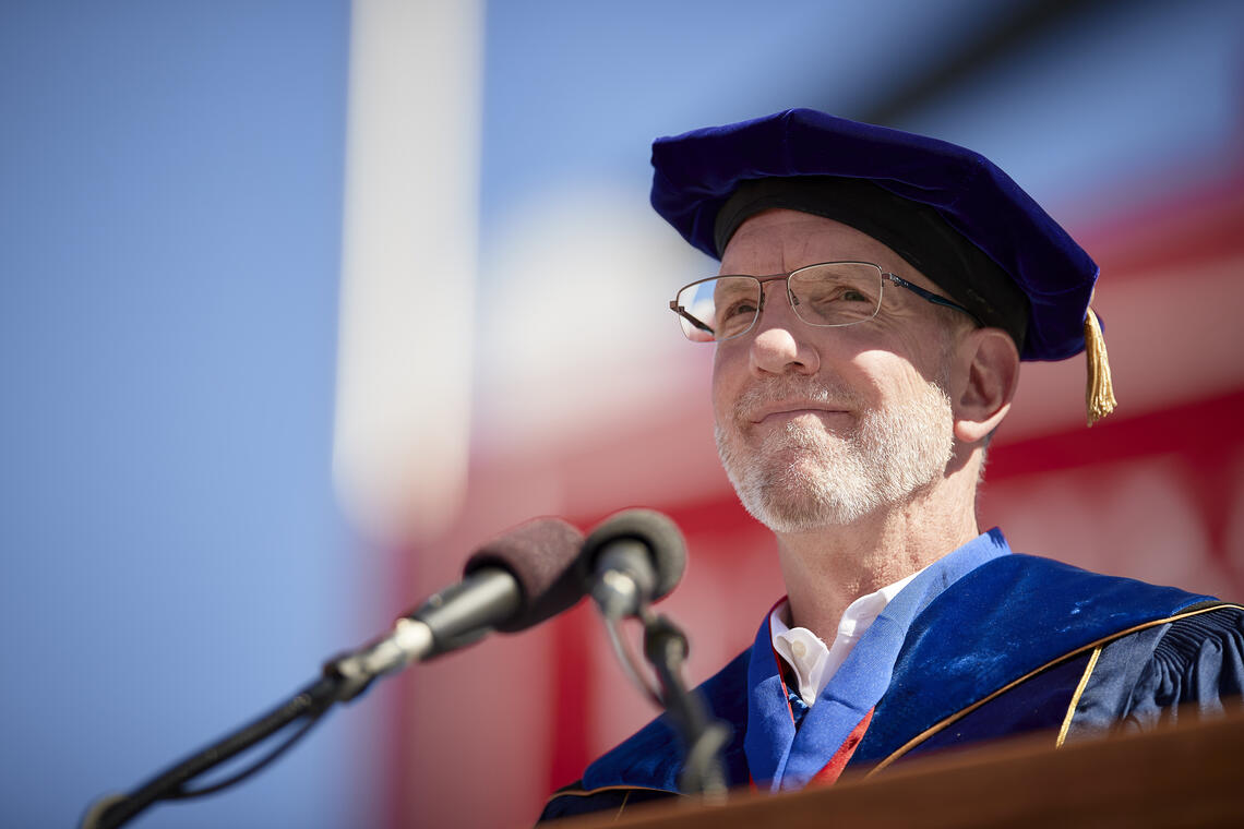 A man in a faculty cap and gown.