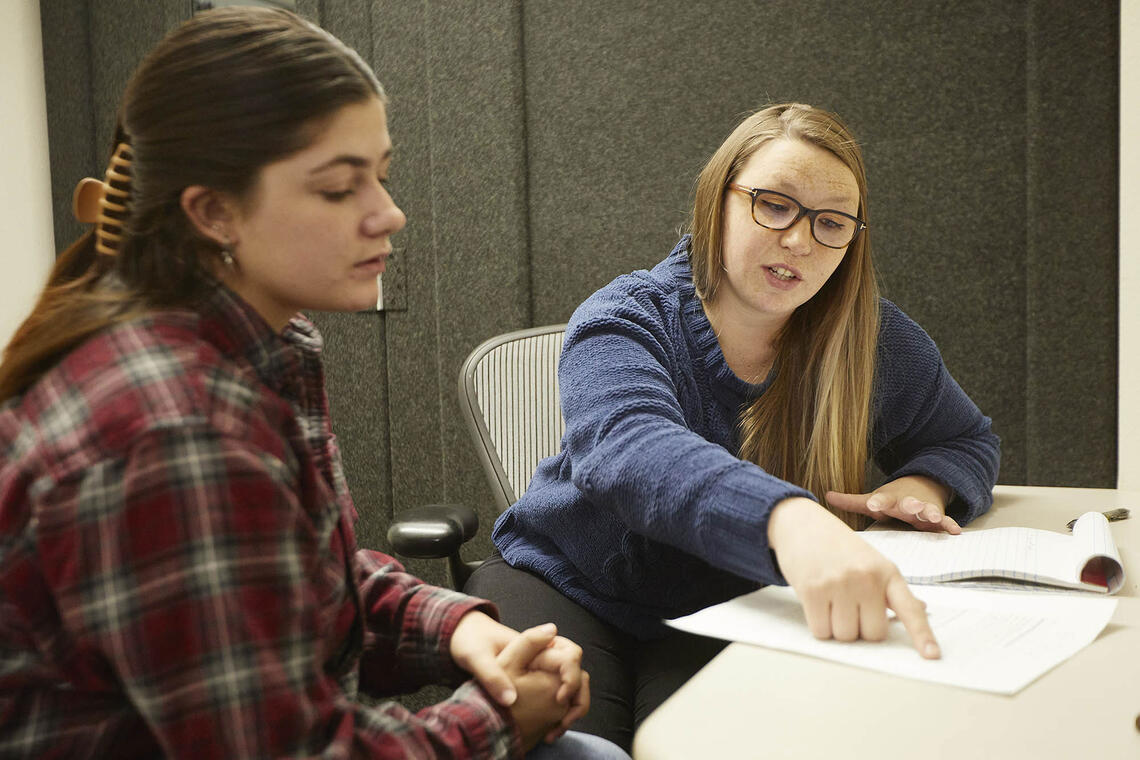 Two people sitting down at a table.