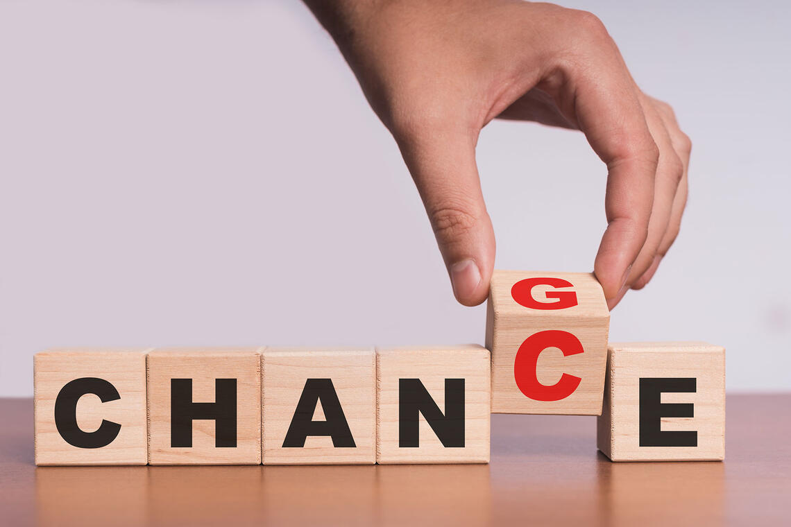 A row of letter blocks spelt out "change" with a person holding one.