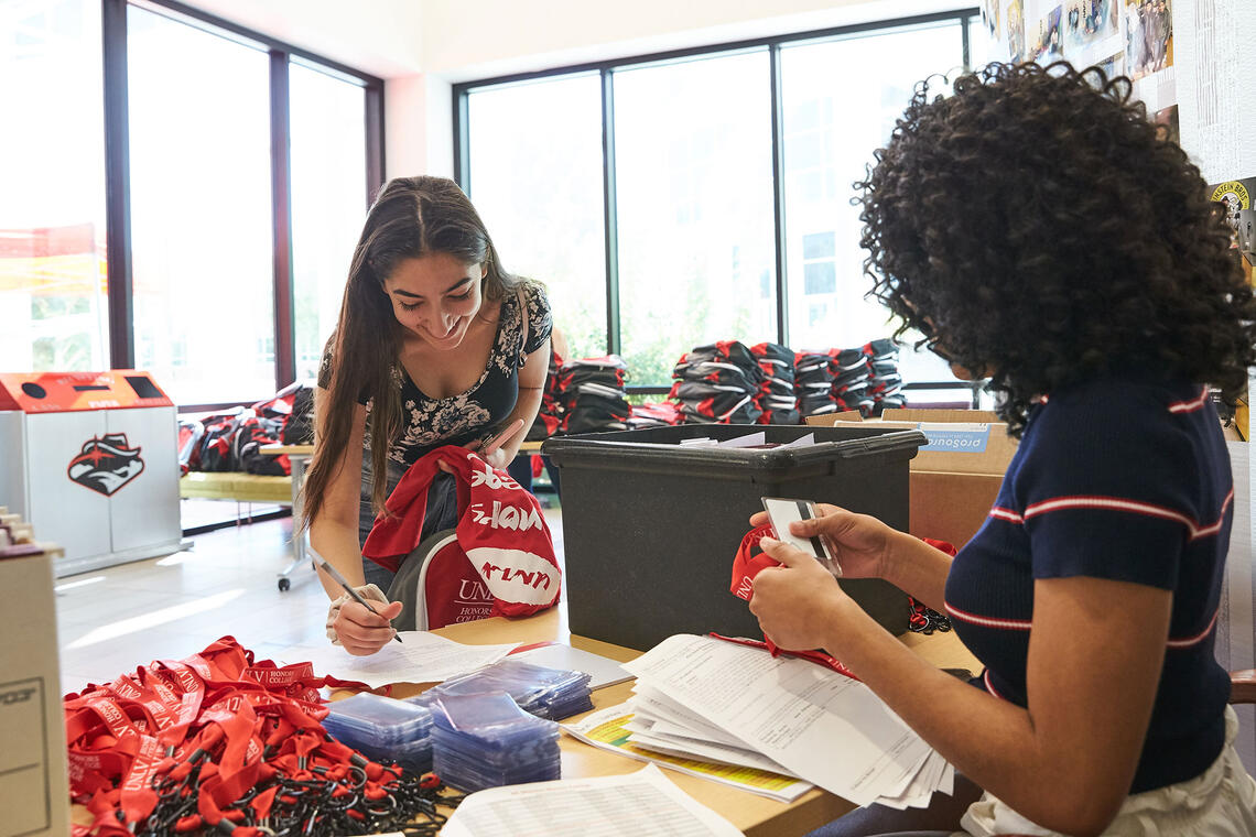 A woman talking to a student at a table