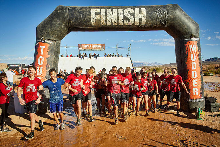 People drenched in mud at the finish line. 