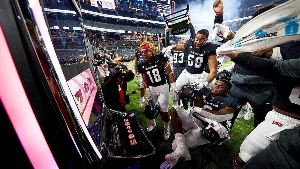 U.N.L.V. Football players playing with a slot machine on the field