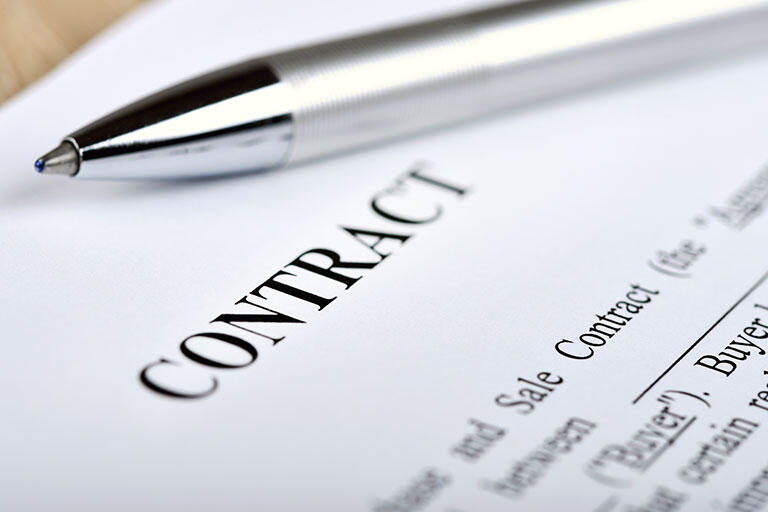Close up shot of a contract document with a pen placed at the top of the page