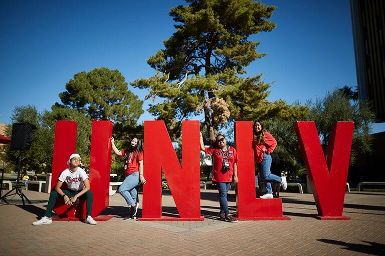 Several students pose with large U.N.L.V. letters