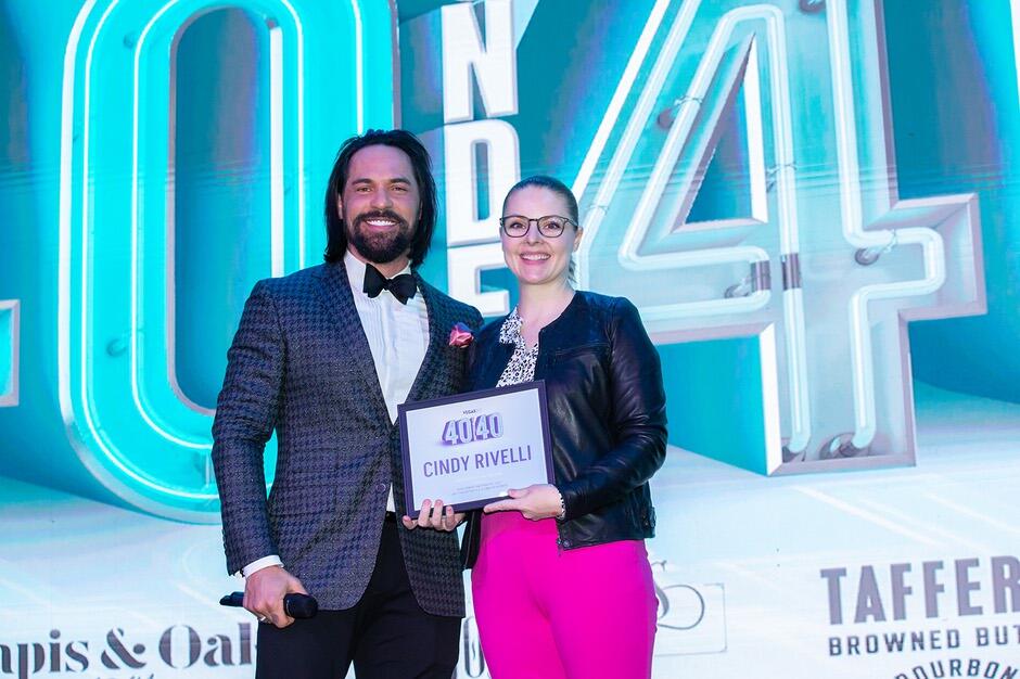 Cindy Rivelli accepts a plaque acknowledging her 40 Under 40 honor by Vegas, Inc. magazine.