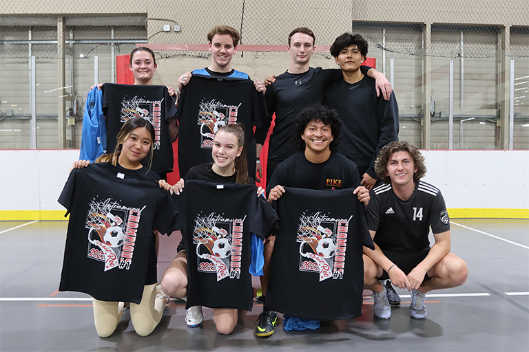 students in a group holding up intramural t shirts