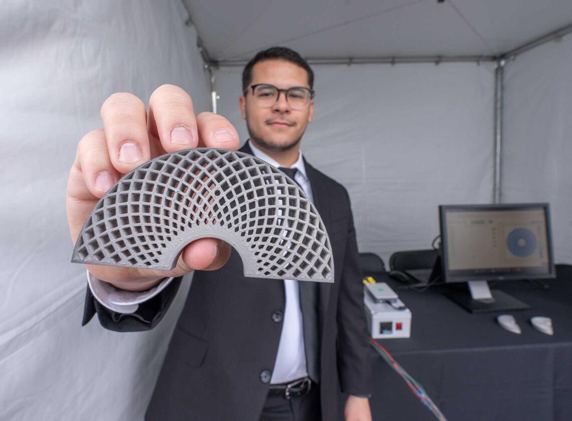 A UNLV Engineering student holds his prototype in front of the camera.